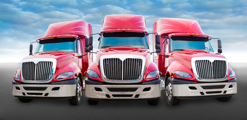 front of 3 parked trucks
